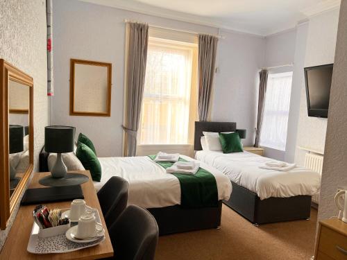 um quarto de hotel com duas camas e uma mesa em The Grove em Weston-super-Mare