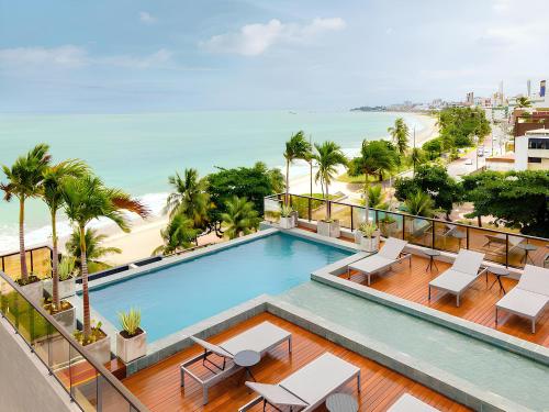 ジョアンペソアにあるApart-hotel Beira-Mar em Manaíraのビーチ付きの建物のバルコニーにあるスイミングプール