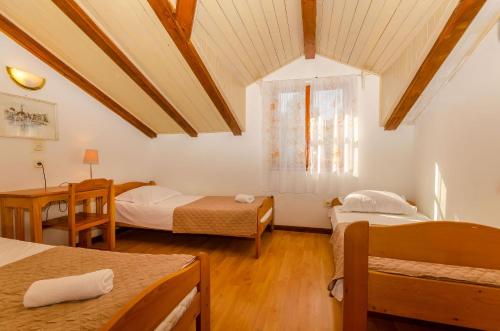 a room with two beds and a table and a window at Apartments Verdun in Ivan Dolac