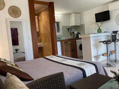 un salon avec un lit et une cuisine dans l'établissement Studio à 200m du centre ville de Porto Vecchio., à Porto-Vecchio