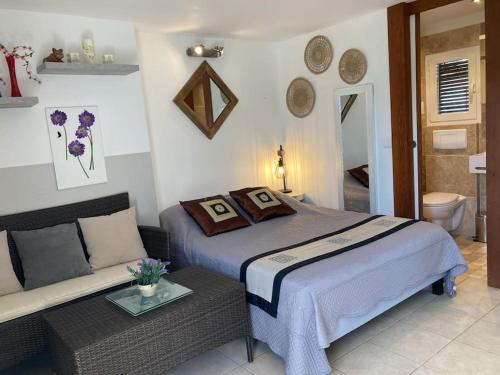 une chambre avec un lit et un canapé dans l'établissement Studio à 200m du centre ville de Porto Vecchio., à Porto-Vecchio