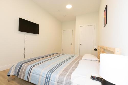 1 dormitorio con 1 cama y TV de pantalla plana en Sleek City Haven-2BR Gem mins to NYC! en Union City