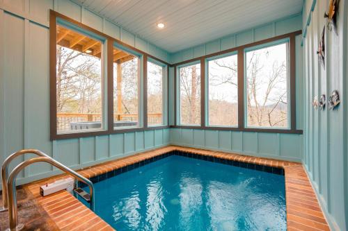 a swimming pool in a house with windows at Romantic Cabin Retreat By Ghosal Luxury Lodging in Gatlinburg