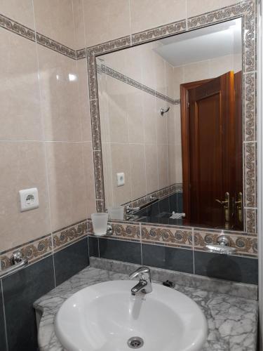 uma casa de banho com um lavatório e um espelho em Carmina fondon 3 em Cangas de Onís