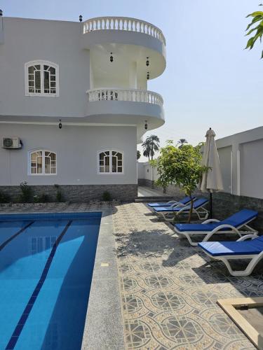 a row of lounge chairs next to a building with a lighthouse at Panorama Hotel in Luxor