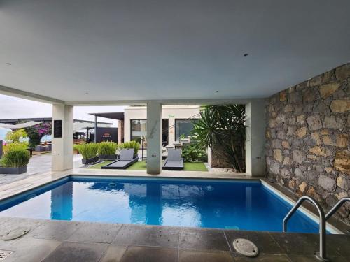 uma piscina numa casa com uma parede de pedra em Ilo Rojo Hotel Boutique em San Miguel de Allende