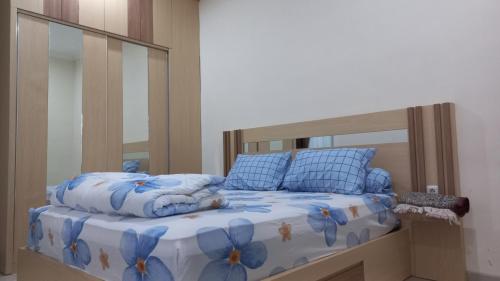 Bett mit blauer Bettdecke und Kissen in der Unterkunft MILLI Home - Family Home Stay in Blimbing