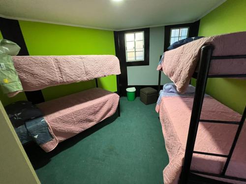 a room with two bunk beds and a green wall at Hostal House 995 in Santiago