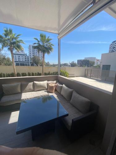 a living room with a couch and a glass table at prestigieuse à casa finance city in Casablanca
