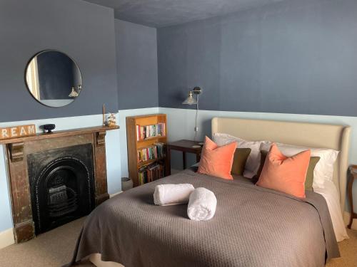a bedroom with a large bed with a fireplace at Beach Hideaway in Shanklin