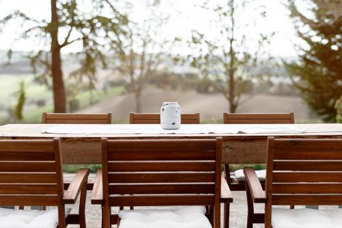 a table with chairs and a cup on top of it at ZEM casolare in Petriolo
