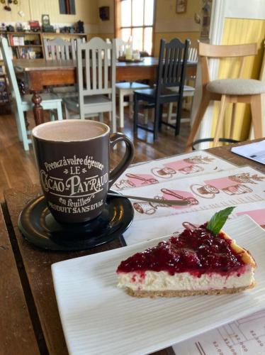a piece of cake on a table next to a cup of coffee at Yendegaia House in Porvenir