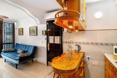 eine Küche mit einem Holztisch und einem blauen Sofa in der Unterkunft Apartamento Ca' Toba in Mogán