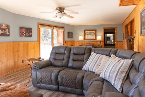 a living room with a couch and a ceiling fan at Lazy Bear Lodge in Florissant with Mountain Views! in Florissant