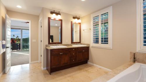 a bathroom with two sinks and a large mirror at SEASCAPE Delightful 3BR Detached KaMilo Home with Heated Pool in Waikoloa