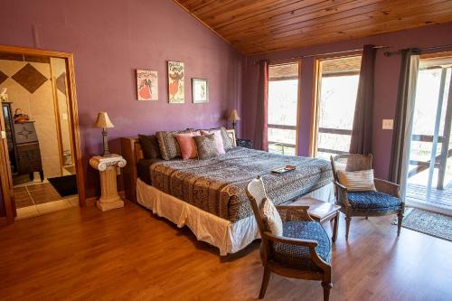 a bedroom with a bed and a table and chairs at Buffalo River Misty Creek Lodge in Vendor