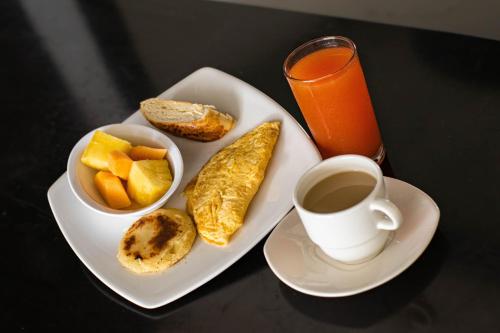 a plate of food with a cup of coffee and fruit at Hotel Abadia in Neiva