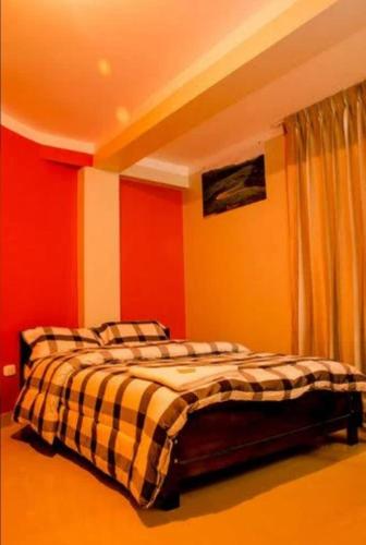 Schlafzimmer mit einem Bett mit roten und gelben Wänden in der Unterkunft HOSTAL BUENAS NOCHES in Chachapoyas