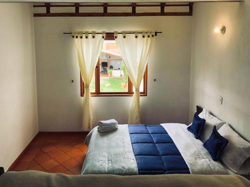 a bedroom with a large bed with a window at HOTEL RUTA 40 VILLA DE LEYVA in Villa de Leyva
