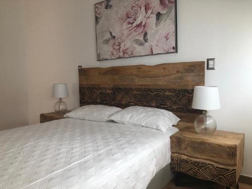 a bedroom with a bed with two lamps and a painting at Impressive City View Apartment A - PH Quartier Marbella in Panama City