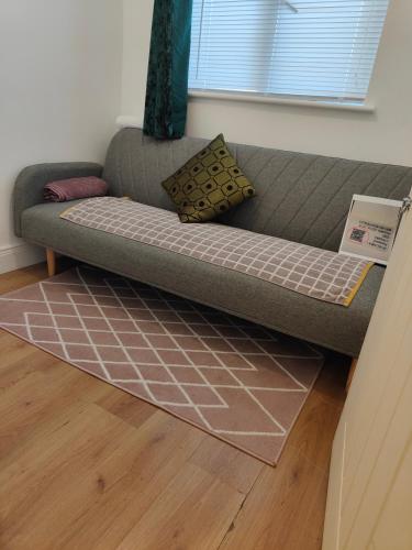 a couch in a living room with a rug at Rose Apartment in Gortlee