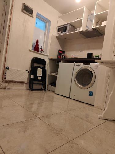 a laundry room with a washing machine and a window at Rose Apartment in Gortlee