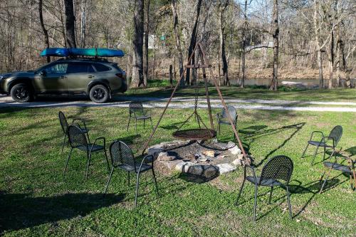 a group of chairs and a fire pit with a car at Buffalo River Misty Creek Lodge in Vendor