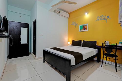 a bedroom with a bed and a yellow wall at OYO Flagship 81266 Slv Hotel in Bangalore