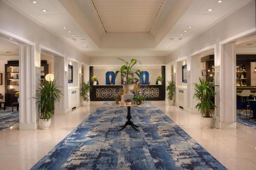 a lobby with a table and plants in it at NH Catania Parco degli Aragonesi in Catania