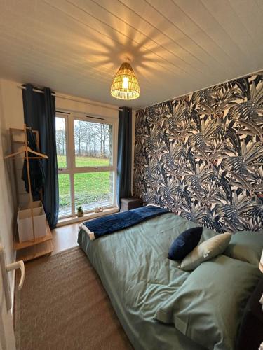 une chambre avec un lit et une grande fenêtre dans l'établissement Very Peaceful Larchamp. Dogs Welcome, à Larchamp