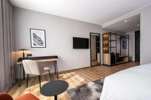 a bedroom with a bed and a desk and a tv at Radisson Hotel Casablanca Gauthier La Citadelle in Casablanca