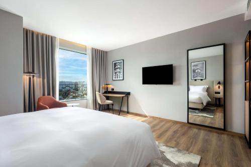 a hotel room with a bed and a mirror at Radisson Hotel Casablanca Gauthier La Citadelle in Casablanca