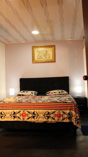 1 dormitorio con 1 cama con una pintura en la pared en Hostal Queens Deluxe en Florencia