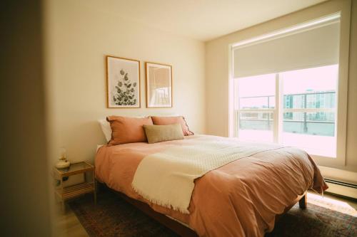 NEW Stylish 2BR Condo with Views in North End في هاليفاكس: غرفة نوم بسرير مع نافذة كبيرة