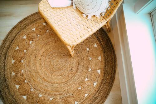 a wicker bench sitting on top of a rug at Chic Cozy Retreat - 2BR - Stunning North End Views in Halifax
