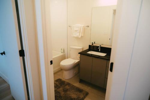 a bathroom with a toilet and a sink and a mirror at *NEW* Stylish 2BR Condo with Views in North End in Halifax