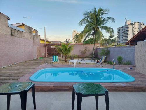 einen Pool mit zwei Tischen und zwei Stühlen in der Unterkunft Casa na Martim de Sá in Caraguatatuba
