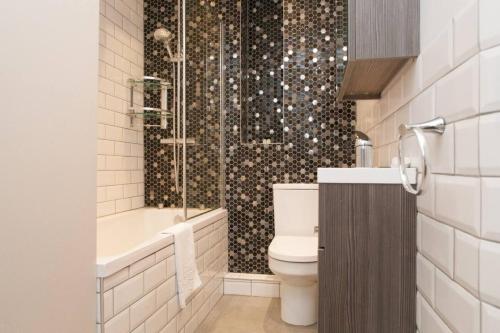 y baño con aseo y ducha. en Cosy 1-bedroom apartment - Putney High Street en Londres