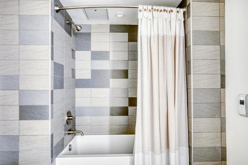 uma casa de banho com uma banheira e uma cortina de chuveiro em W Hollywood 1BR w BBQ Pool Gym WD nr TJ LAX-479 em Los Angeles