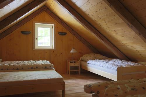 a attic bedroom with two beds and a window at Chalupa Granát in Kořenov