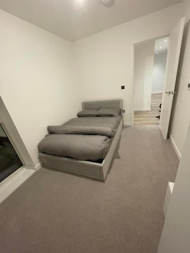 ein Schlafzimmer mit einem Bett in einem weißen Zimmer in der Unterkunft West Heights SE in Croydon