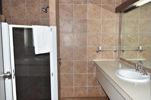a bathroom with a sink and a shower at Pacific Gardens Hotel in Goroka