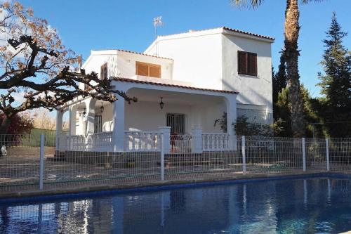 a white house with a fence next to a swimming pool at Chalet in PEÑISCOLA in Peñíscola