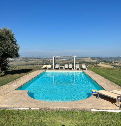 a swimming pool with a gazebo in a field at Agriturismo Bibiano38 in Treia