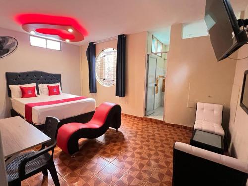 ピウラにあるHospedaje zafiroのベッド2台、テレビ、ソファが備わる客室です。