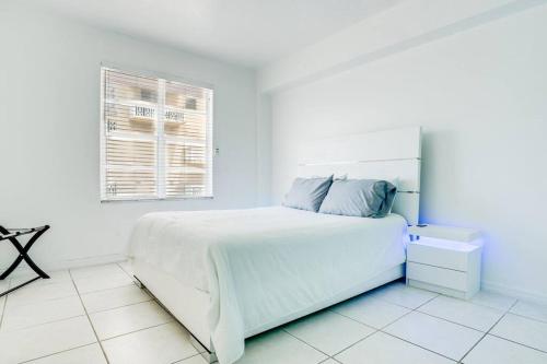 a white bedroom with a bed and a window at Amazing apartment in Miami Beach in Miami Beach