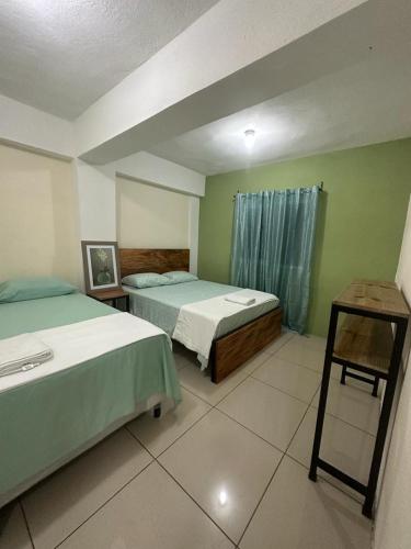 a hotel room with two beds and a table at Grupo Small Ville in Guatemala