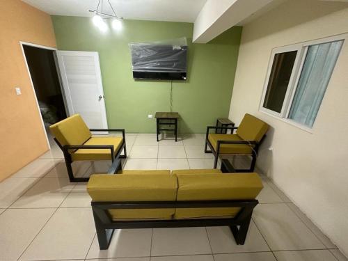 a living room with a couch and chairs and a tv at Grupo Small Ville in Guatemala