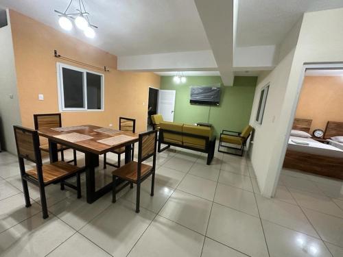 a dining room with a table and chairs and a bedroom at Grupo Small Ville in Guatemala