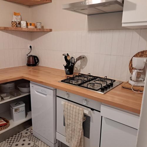 une cuisine avec une cuisinière et un comptoir dans l'établissement Maison de charme en campagne, 5 min du haras du pin, à Nonant-le-Pin